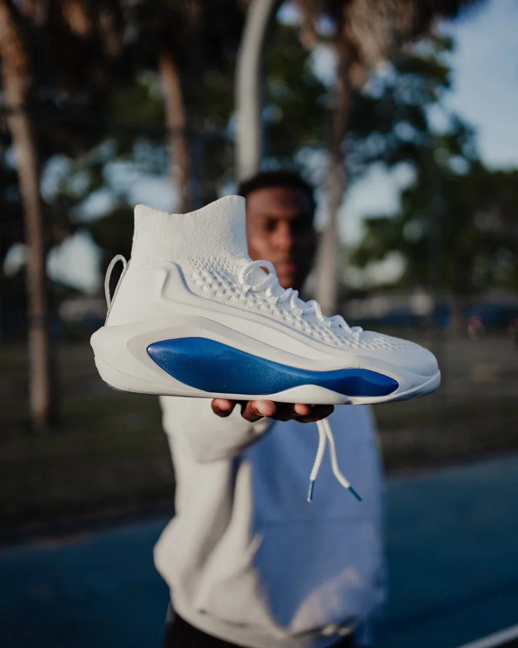 EQLZ x JLEW signature shoe held by Jordan Lewis